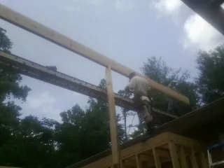 Carpenter setting a ridge beam over a new addition frame — Ice Dam Removal by Roofing Brothers in Rickman