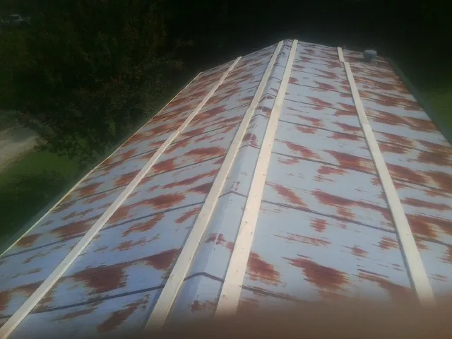 Rusted metal roof panels with new wood purlins before replacement — Storm Damage Roof Repair in Rickman by Roofing Brothers