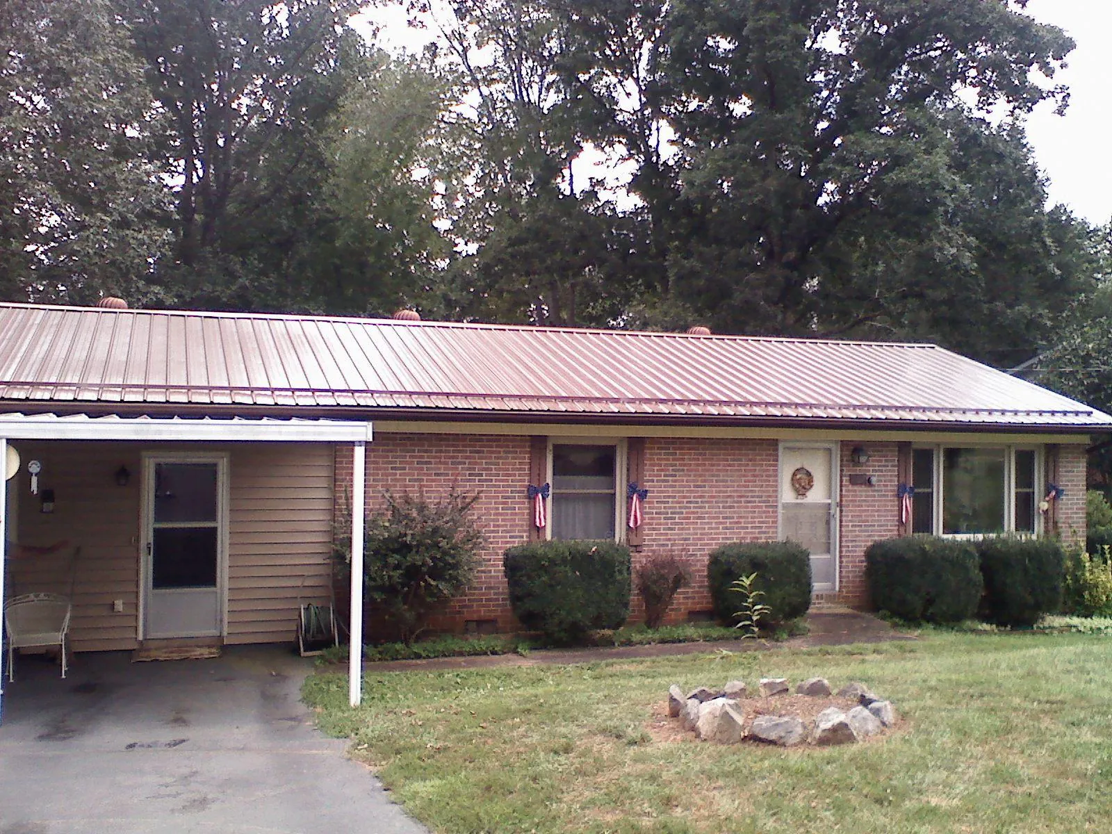 Bronze metal roof and carport on a brick ranch home — Roof Repair work by our crew in Rickman